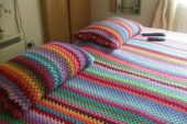 Renkli iplerden işlenilmiş örgü yatak örtüsü